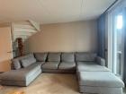 Grote U-vormige bank met chaise longue en hocker